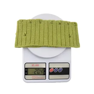 Detail shot of a distressed green knitted wool headband resting on a scale showing 20.4g weight.