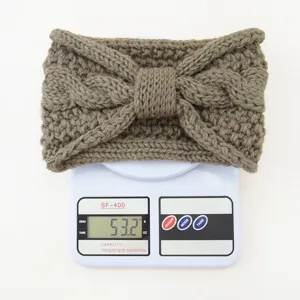 Detailed close-up view of the knitted bow headband showcasing texture and weight display.