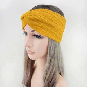 Detailed view of the yellow bubble fabric twist headband, showing the stylish crinkled texture.