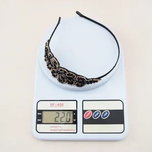 Detail view of a black crystal embellished headband, showcasing exquisite beadwork on scale.
