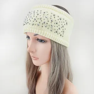 Gedetailleerde close-up van een gezellige beige gebreide haarband met sprankelende zilveren strass.