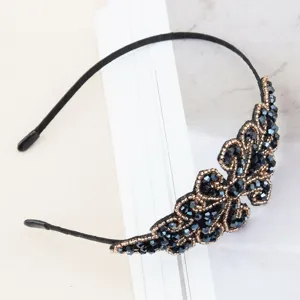 Crystal beaded headband detail close up, elegant black and gold rhinestone hair hoop ornament.
