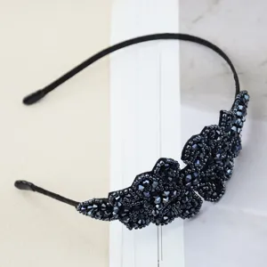 Close-up of black beaded crystal headband, elegant handmade design detail showing dark sparkling crystals.