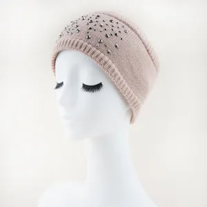 Detail van de gebreide haarband met strass steentjes, warme accessoires voor de winter.