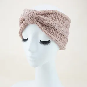 Detailed view of the knitted twist headband, showing soft yarn texture and bow detail.
