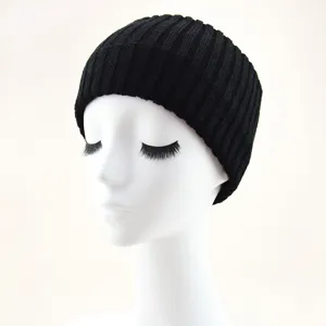 Vue détaillée du bandeau tricoté côtelé noir, accessoire de cheveux d'hiver élégant et chaud.