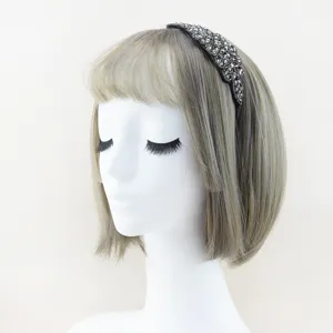 Closeup detail of a sparkling rhinestone crystal headband on a mannequin for elegant hairstyles.