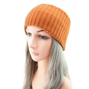 Bonnet en tricot côtelé orange présenté sur tête de mannequin, vêtement chaud élégant.