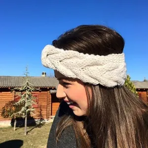 Gedetailleerd overzicht van een creme witte kabelgebreide hoofdband, warme haaraccessoire.