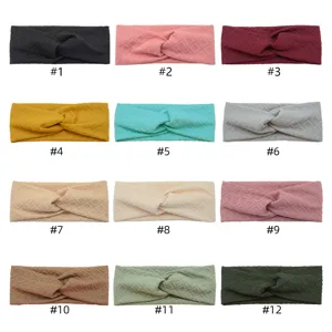 Detailed view of twisted cross headbands in various colors, diamond lattice stretch fabric.