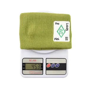 Vue détaillée d'un bandeau en tricot vert montrant le poids du produit sur une balance.