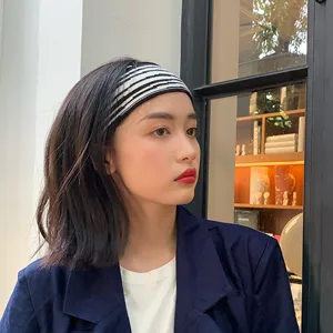 Bandeau tricoté à rayures zébrées pour femme, accessoire de cheveux noir et blanc élégant.