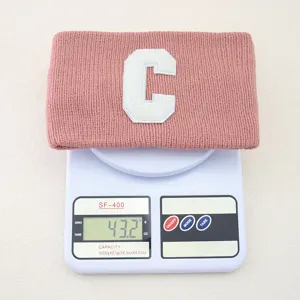 Vista dettagliata della fascia in maglia rosa con toppa lettera C e peso del prodotto.
