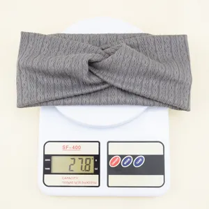 Détail en gros plan du bandeau tricoté gris montrant son motif losange texturé et son poids.