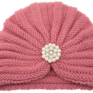 Detailed close-up of women winter knitted turban hat with pearl rhinestone brooch decoration.