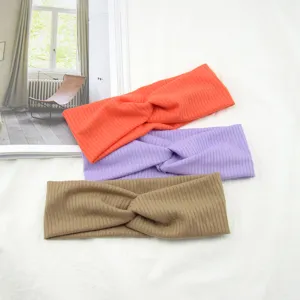 Detail view of stylish cross knit headbands in vibrant colors, breathable and elastic.