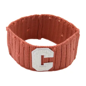 Distressed knit headband in rust red featuring a white letter C patch for daily sports.