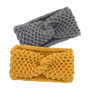 Gros plan de banderoles croisées en tricot, matière laine douce, gris et jaune.