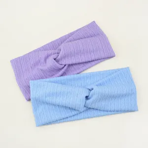 Détail du bandeau croisé en tricot texturé, accessoire élastique pour le sport et yoga.