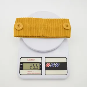 Bandeau tricoté jaune avec boutons, vue détaillée montrant le poids sur une balance numérique.
