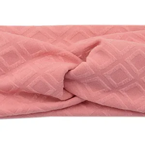 Detailed view of the pink knitted twist headband with geometric diamond pattern for daily wear.