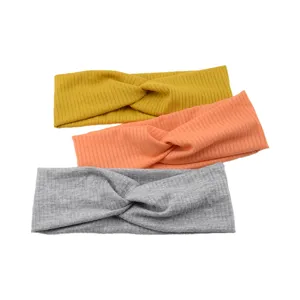 Close up of ribbed twisted headbands in yellow, orange and grey, soft elastic fabric.