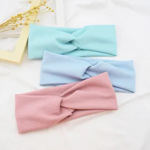 Detailed flat lay shot showing fabric hairbands with a twisted knot design in pastel colors.