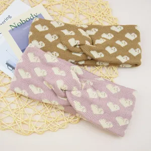 Strick-Stirnband mit Herz-Muster, gemütliches Haaraccessoire im praktischen Detailblick.