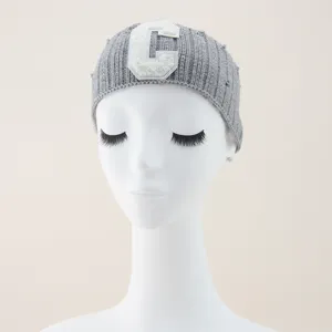 Gray knitted hairband with white letter C patch, trendy and comfortable for sports and daily wear.