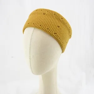 Detailed close-up of mustard yellow knitted headband showing hollow out texture details.