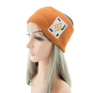 Bandeau tricoté orange pour femmes, large bandeau de sport d'hiver avec patch brodé chic.