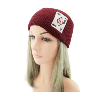 Bandeau tricoté bordeaux pour femme, large bandeau de sport d'hiver avec écusson, accessoire chic.