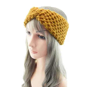 Gros plan détaillé sur le bandeau en tricot grossier moutarde, accessoire croisé.