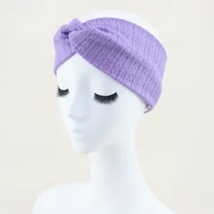 Détail en gros plan du bandeau croisé en tricot violet, tissu élastique doux pour le yoga.