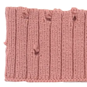 Close-up view of the pink distressed knit texture, showing unique holes and soft fabric details.