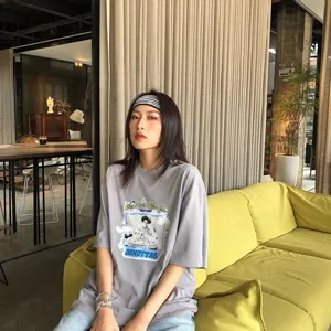 Vue détaillée du bandeau rayé élégant et du t-shirt graphique gris dans un intérieur chic.