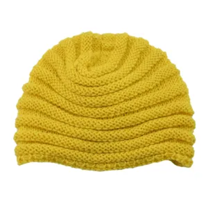 Close-up detail of the yellow knitted beanie hat, showing wave texture and cozy knit craft.