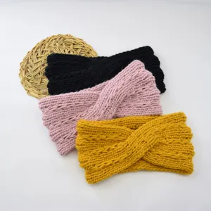 Detailed view of chunky knit cross headbands in black, pink, and yellow. Textured winter ear warmer accessory.
