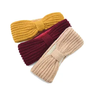 Close-up of plus fleece knitted bow headband detail, warm wool hair accessory, autumn winter ear warmer.