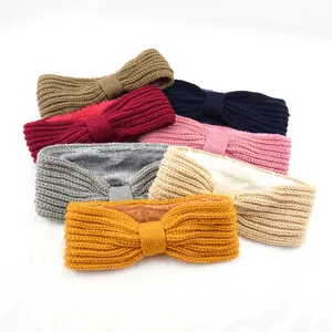 Plush fleece lined knitted winter headband with cute bow detail, warm hair accessories.
