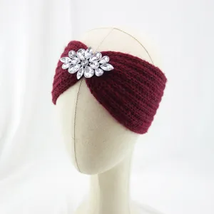 Detailed close-up of burgundy knitted rhinestone headband showing sparkling crystal brooch design.