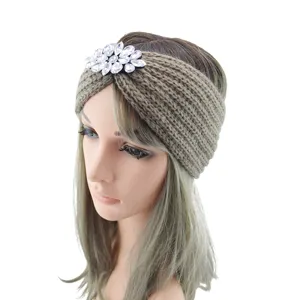 Detail view of the chunky knit winter headband adorned with a sparkling crystal flower.