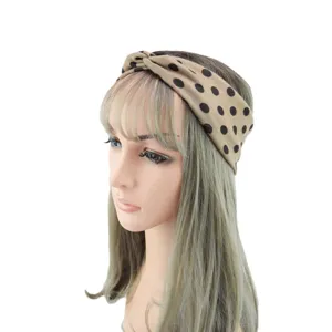 Detail view of the polka dot knotted fabric headband, showing the stylish cross design.