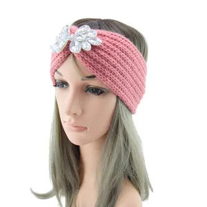 Detailed view of the pink knitted headband featuring a sparkling crystal flower decoration.