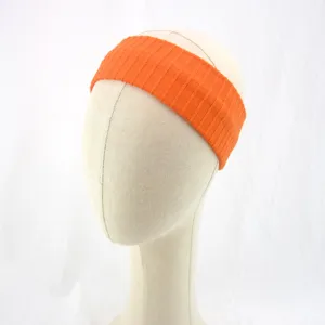 Dettaglio fascia per capelli in maglia a coste arancione, accessorio sportivo elastico yoga.