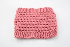Primer plano de la textura de la diadema de punto rosa grueso, con diseño de burbujas.