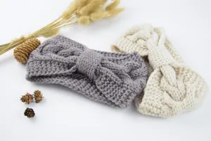 Gedetailleerd overzicht van warme gebreide haarband met strik, gezellig winterhaaraccessoire.