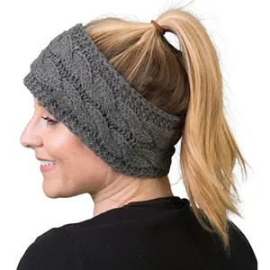 Primo piano della fascia in maglia a trecce grigia di profilo, accessorio per capelli invernale.