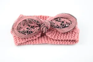 Dettaglio ravvicinato della fascia in maglia rosa con fiocco, rete e ricami di paillettes.