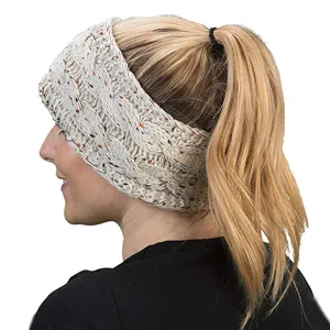 Vista dettagliata di una fascia per capelli lavorata a maglia beige con macchie.